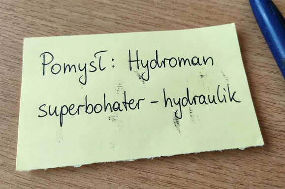 Zdjęcie żółtej karteczki z odręcznym napisem: Pomysł: Hydroman superbohater - hydraulik